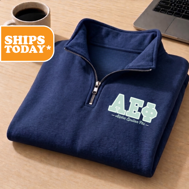 A navy blue zip-up jacket with the letters 'AE' printed on it, placed on a wooden surface next to a laptop.