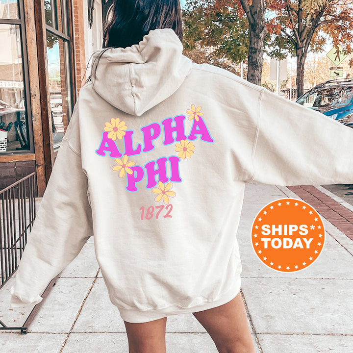 A person wearing a white hoodie with the text "ALPA Phi 1872" printed on it, standing on a sidewalk with trees and a building in the background.