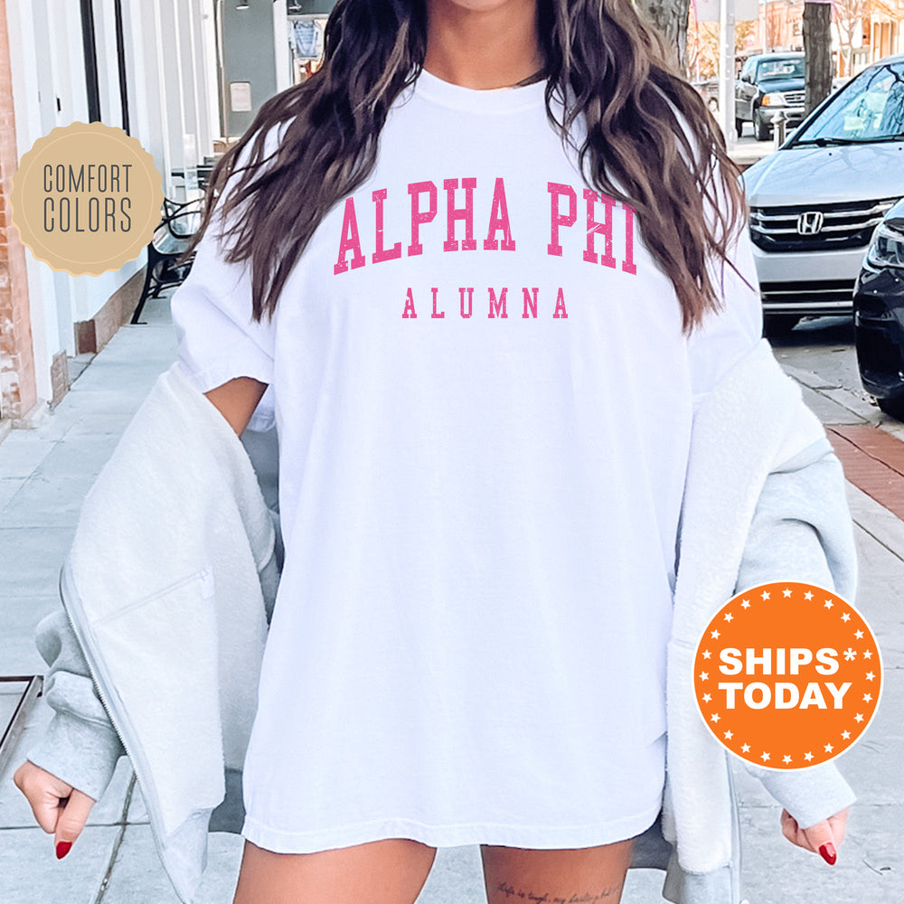 a woman wearing a white shirt with pink letters on it