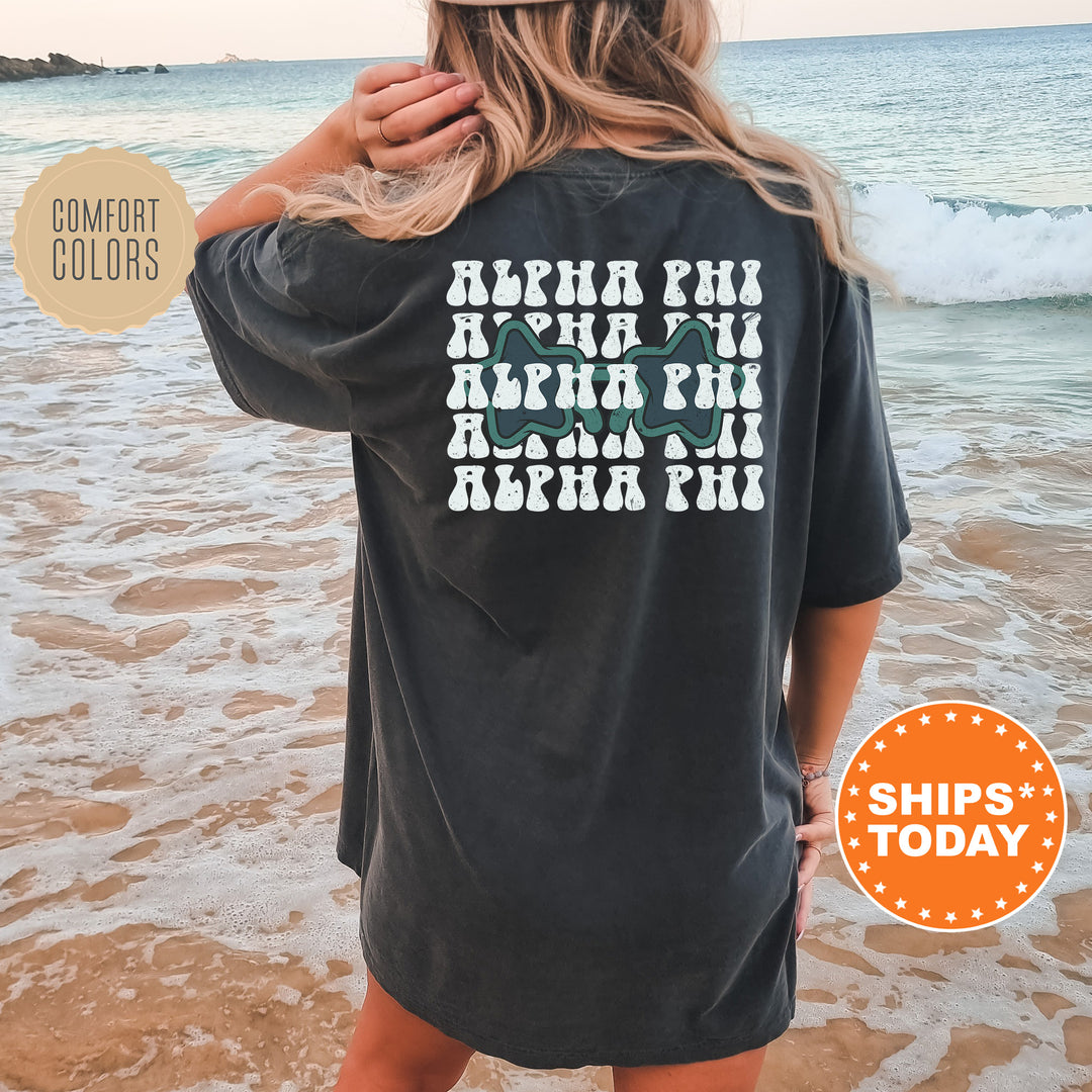 a woman standing on a beach wearing a black shirt