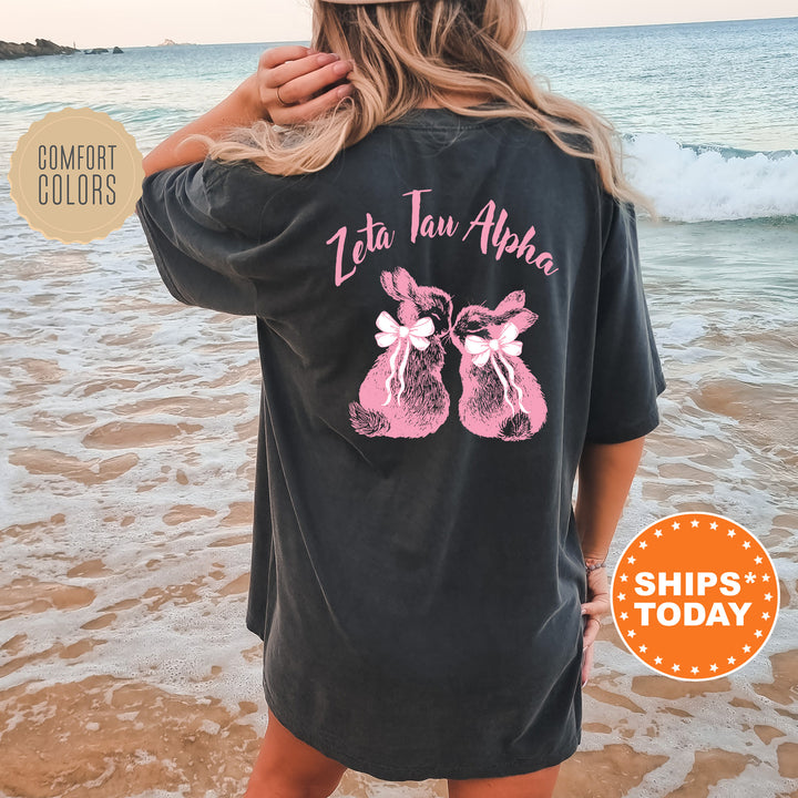 a woman standing on a beach wearing a black shirt