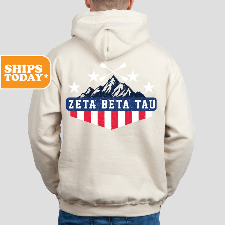 a man wearing a white hoodie with the words zeta beta tau on