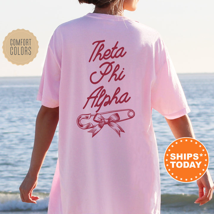 a woman standing on a beach wearing a pink shirt