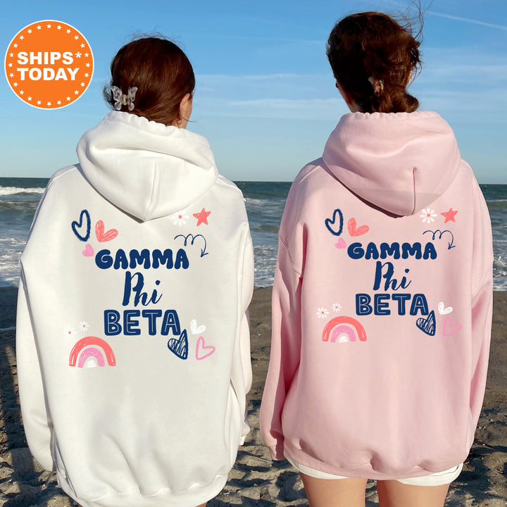 two girls wearing matching sweatshirts on the beach