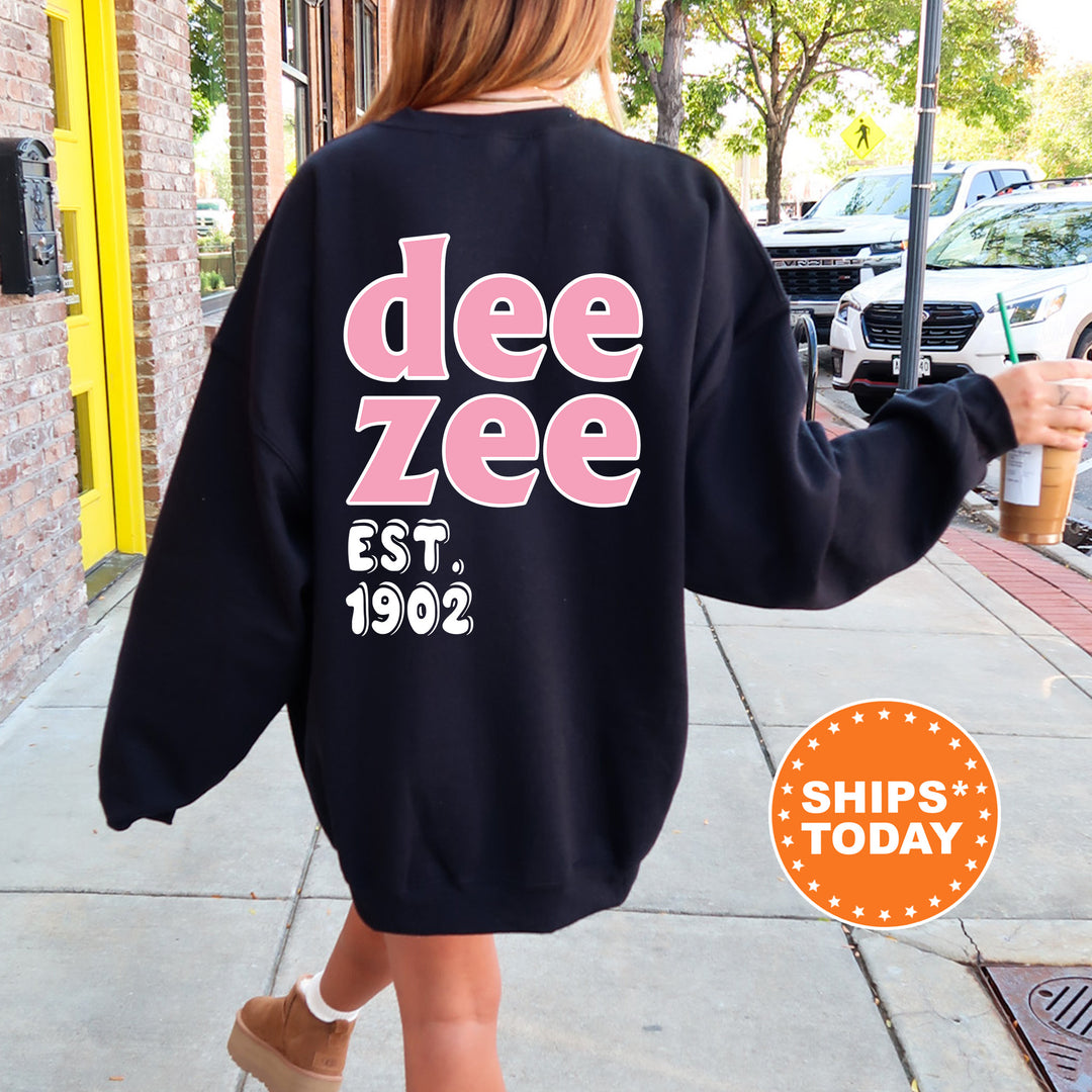A person wearing a black sweatshirt with pink text and numbers is walking on a sidewalk.