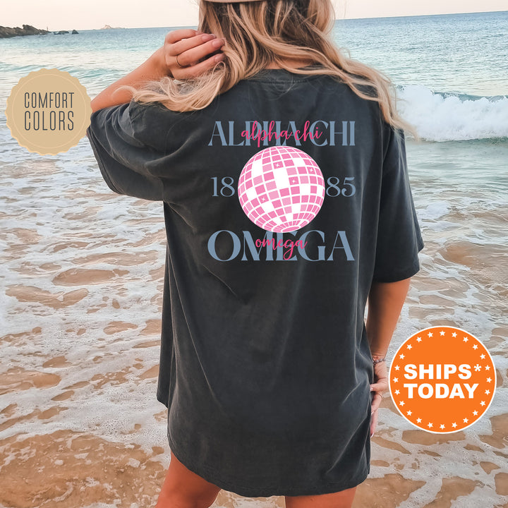 a woman standing on a beach wearing a black shirt