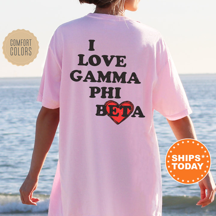 a woman standing on a beach wearing a pink shirt