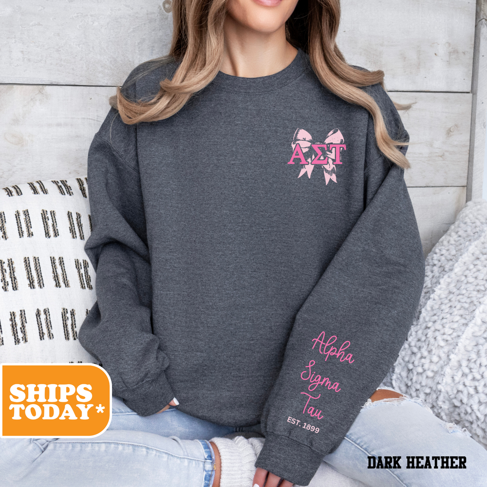 a woman sitting on a bed wearing a gray sweatshirt