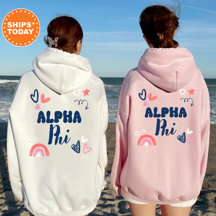two girls wearing pink and white sweatshirts on the beach