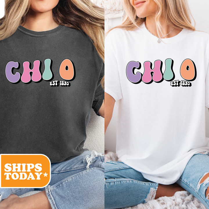 two women sitting on a bed wearing matching shirts