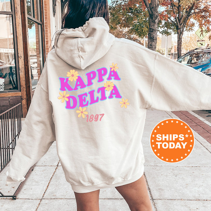 A person wearing a white hoodie with the text " Kappa Delta" and "1897" printed on it, standing on a sidewalk.