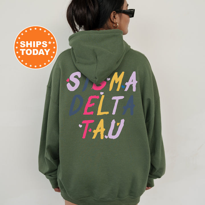 a woman wearing a green sweatshirt with the words suma delta tau printed on it