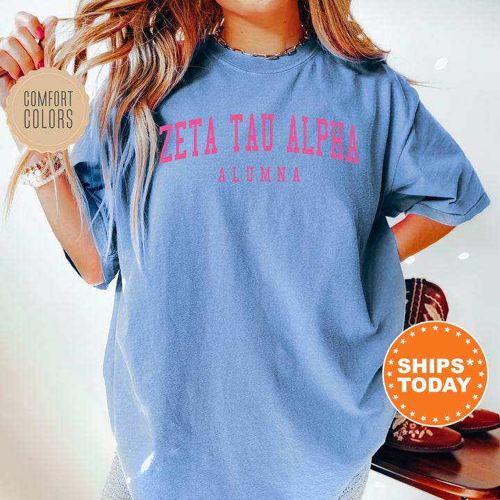 a woman wearing a blue shirt with pink letters on it