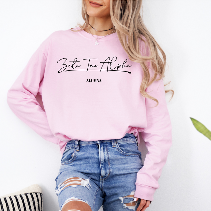 a woman wearing a pink sweatshirt and ripped jeans