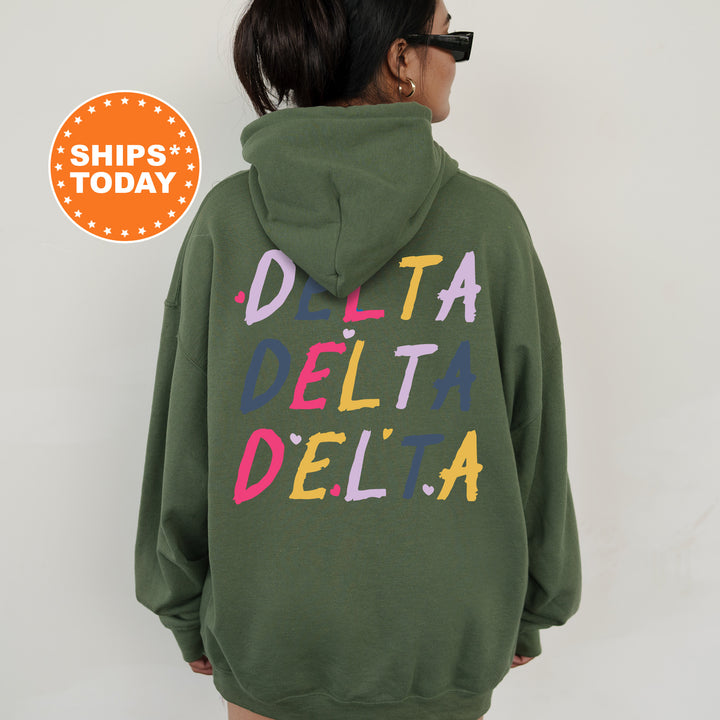 a woman wearing a green sweatshirt with the words delta delta written on it