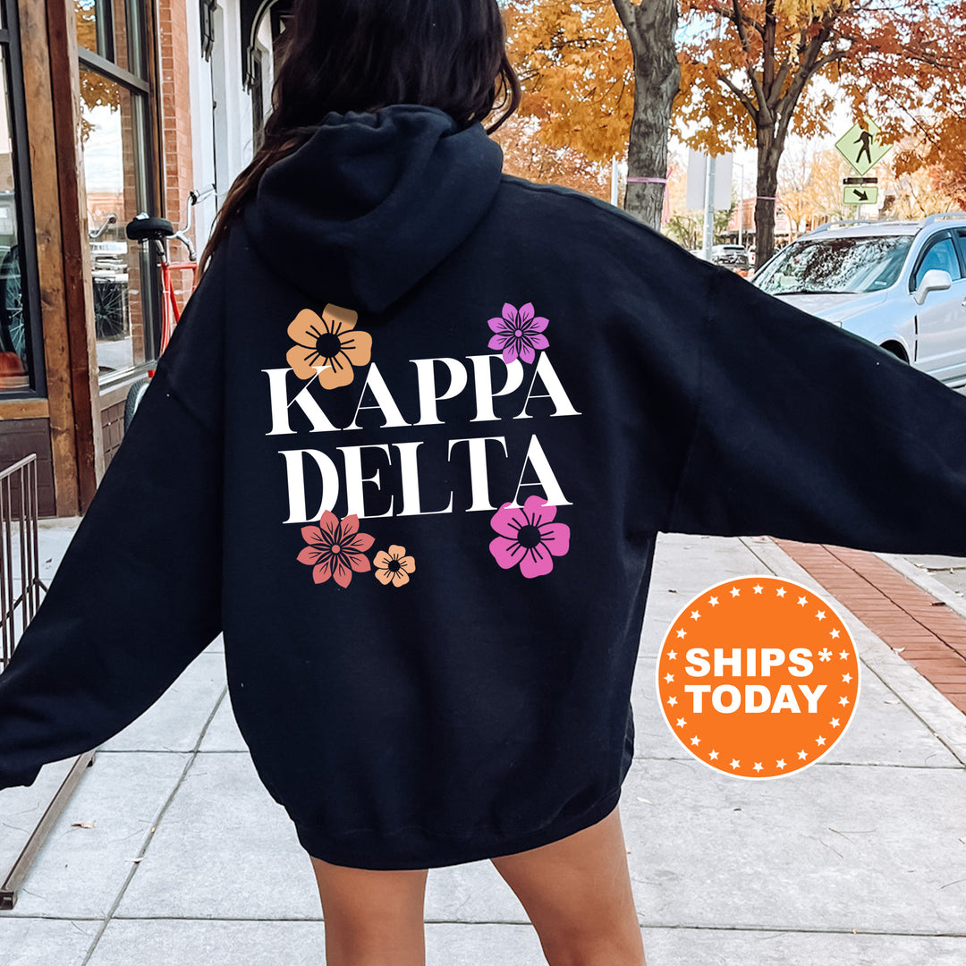 a woman in a black hoodie that says kapa delta
