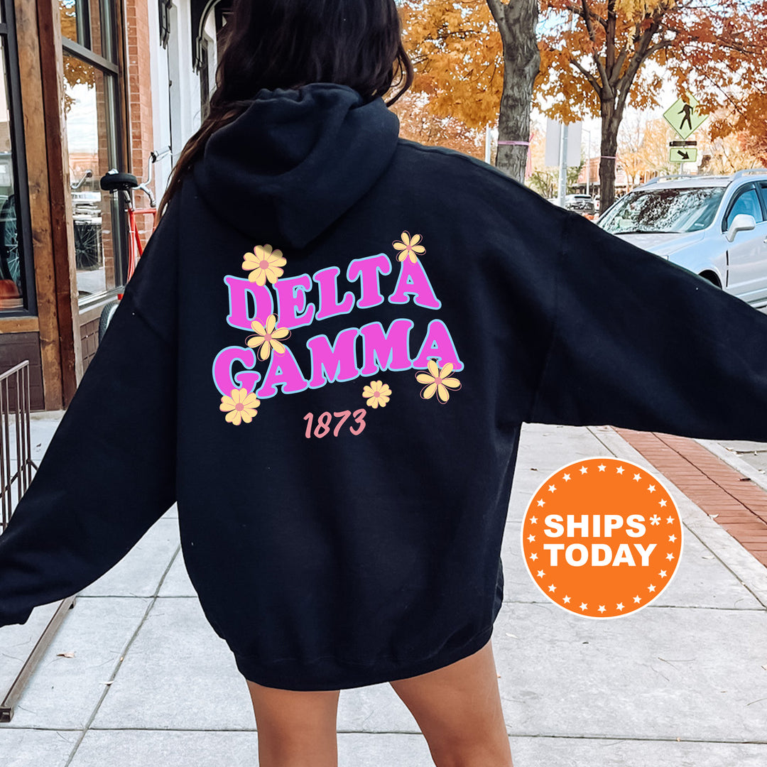 A person wearing a black hoodie with the Delta Gamma sorority logo and the year 1873 printed on it, standing on a sidewalk.