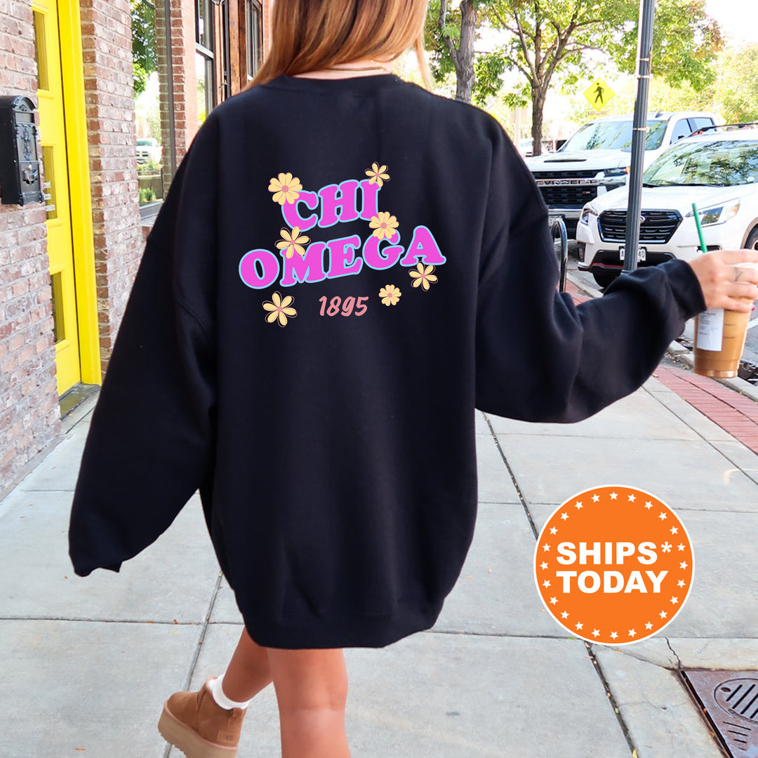 A person wearing a black sweatshirt with the text "CHI Omega" and "1995" printed on it, walking down a sidewalk.