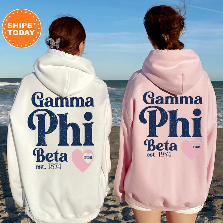 two girls wearing pink and white hoodies on the beach