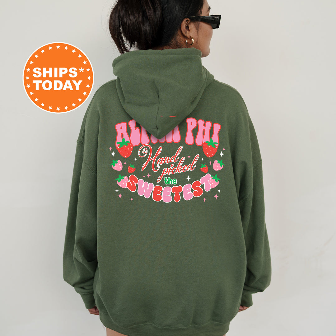a woman wearing a green hoodie with a strawberry print on it
