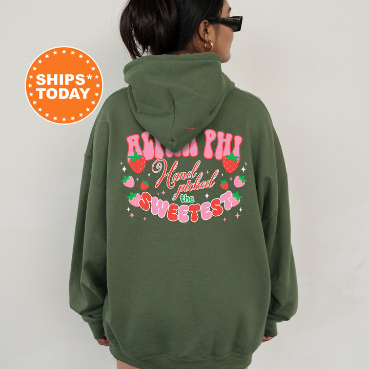 a woman wearing a green hoodie with a strawberry print on it