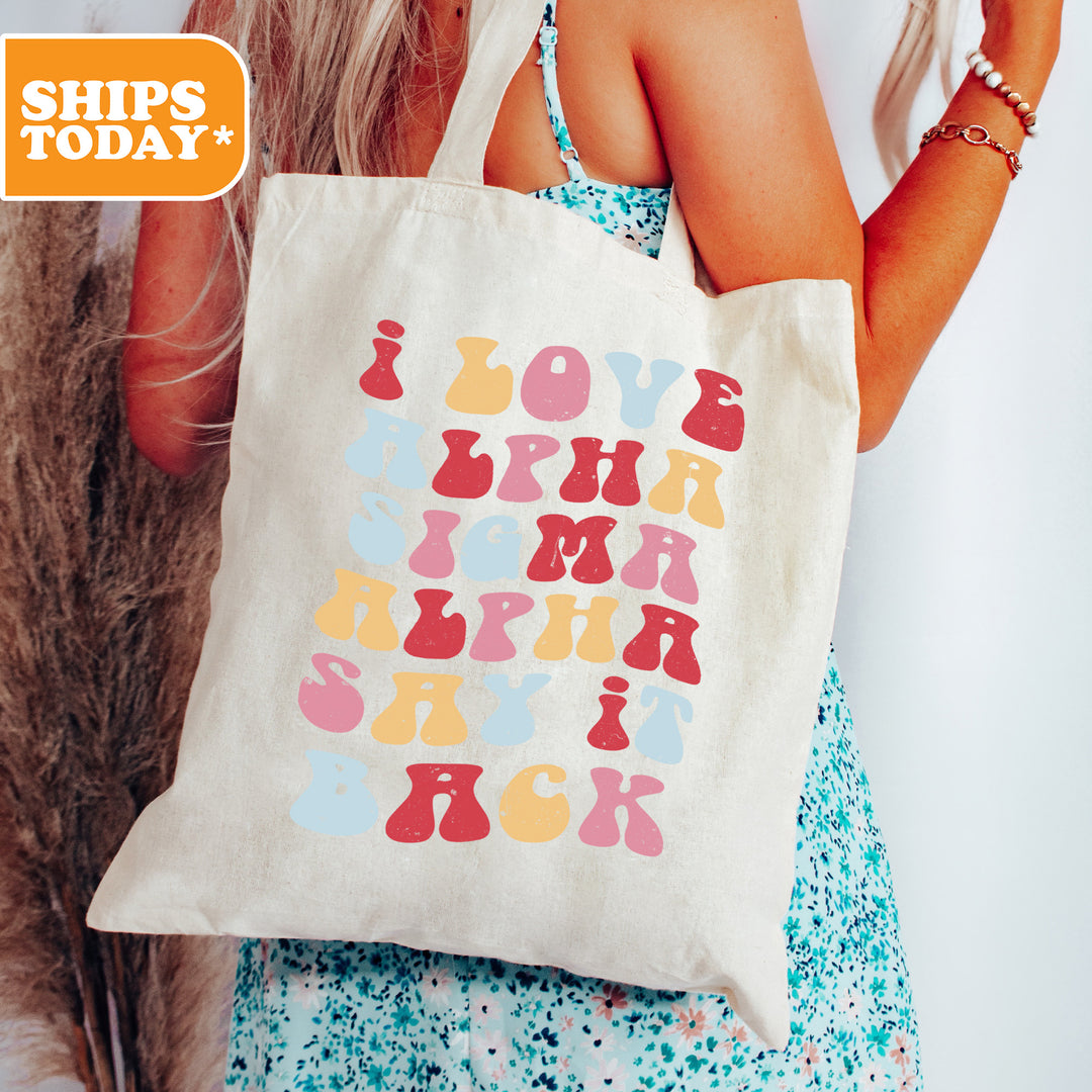 a woman holding a tote bag with letters on it