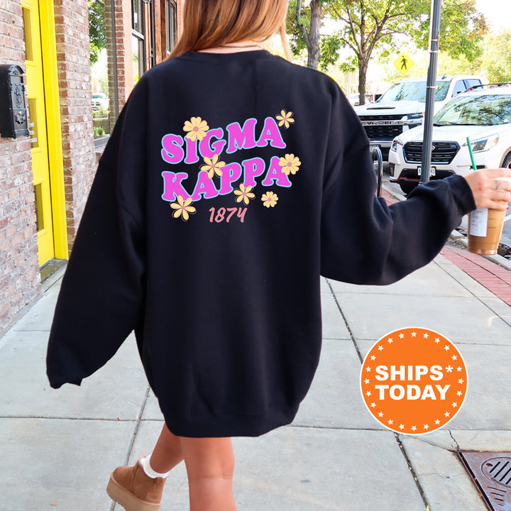 A person wearing a black sweatshirt with the text "SIGMA KAPPA 1874" printed on it, walking down a sidewalk.