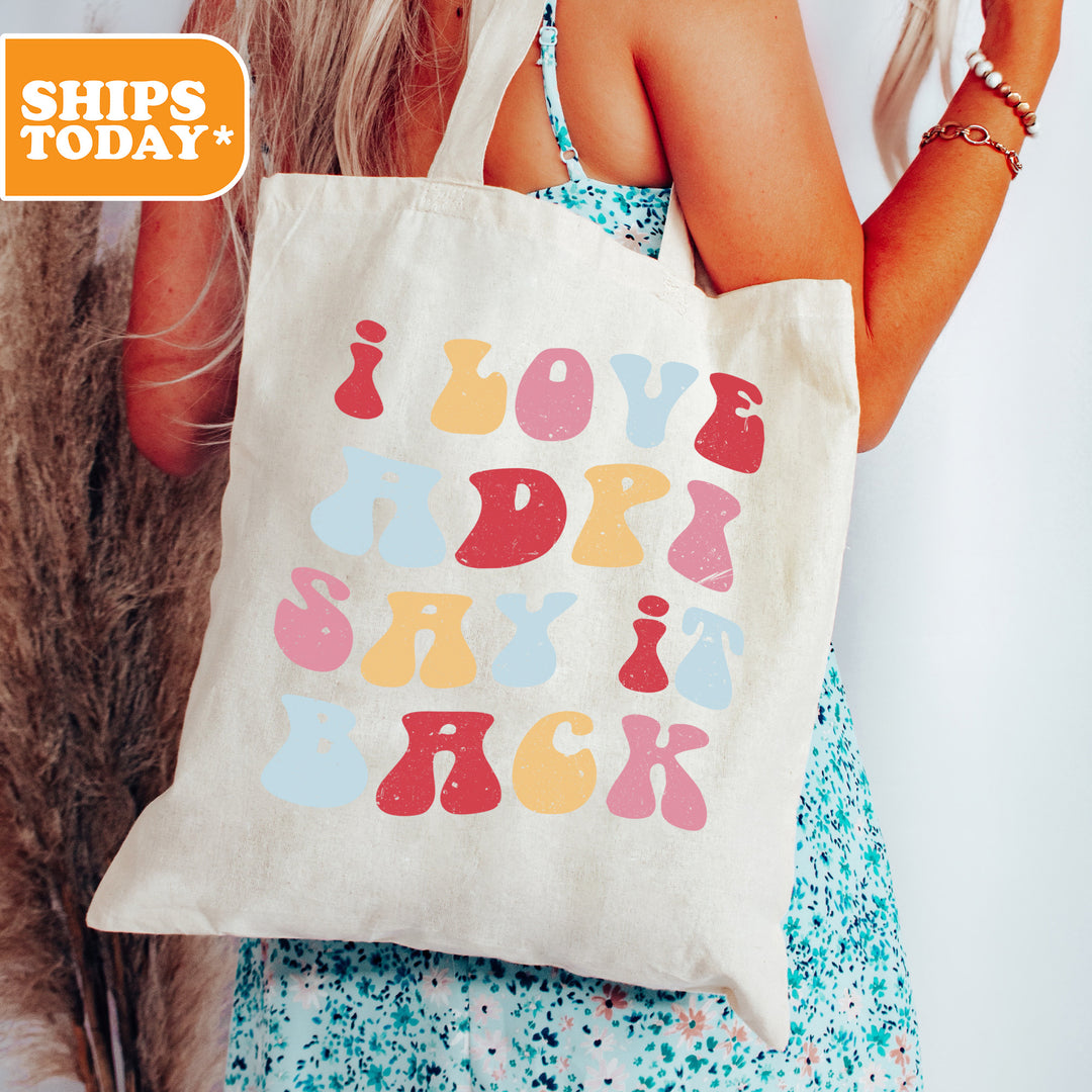 a woman holding a tote bag with a message on it