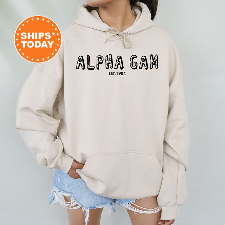 a woman wearing a white hoodie with the words alpha gam printed on