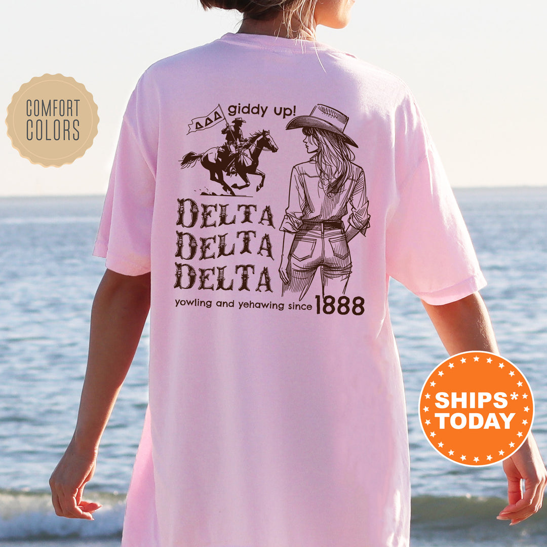 a woman wearing a pink delta delta shirt on the beach