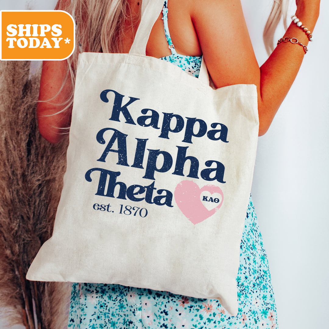 a woman holding a tote bag that says kappa alpha thea