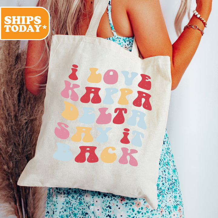 a woman is holding a tote bag with letters on it