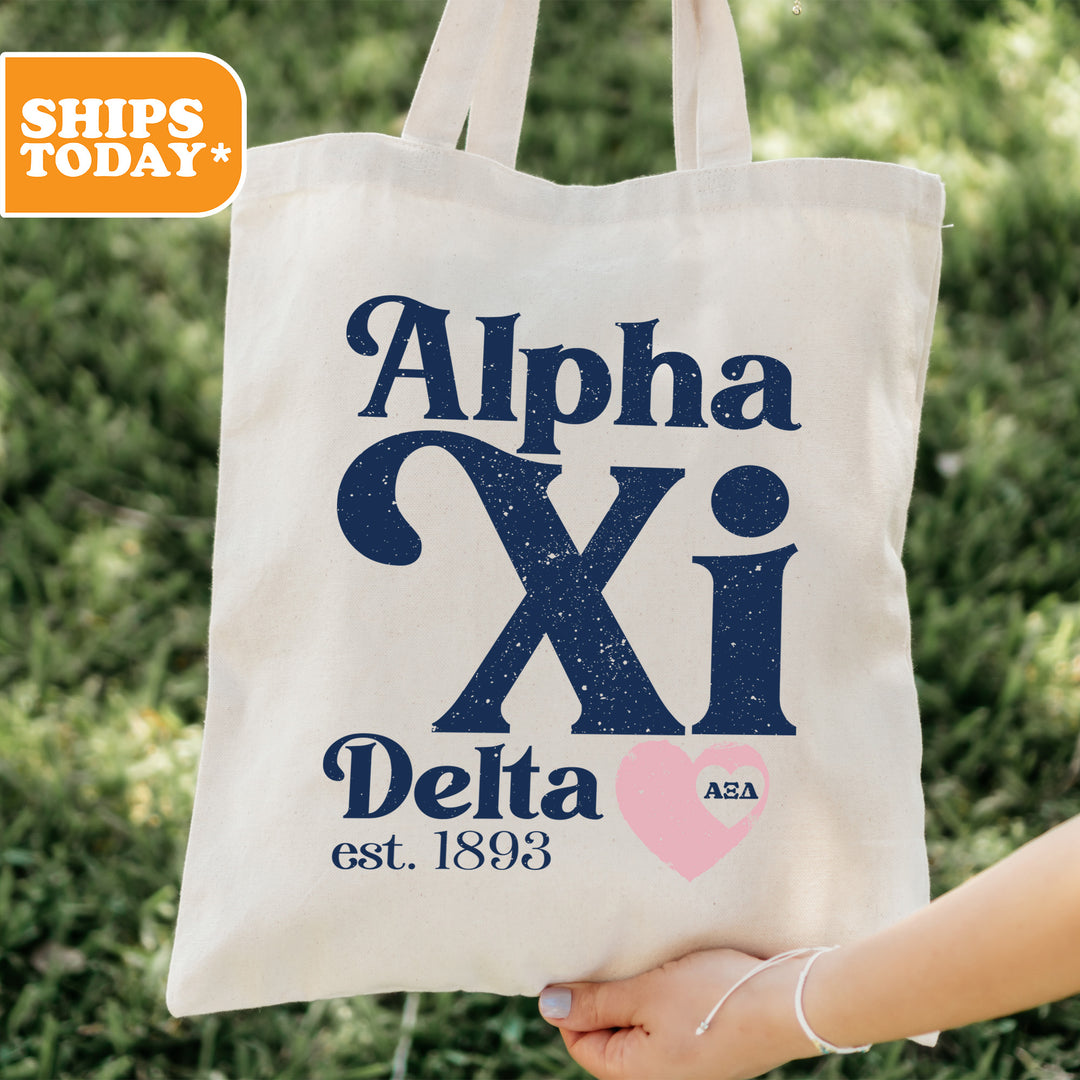 a person holding a tote bag that says alpha xi delta