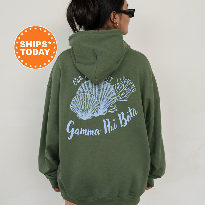 A person wearing a green hoodie with a graphic design of shells and the text "Gamma Phi Beta" printed on the back.