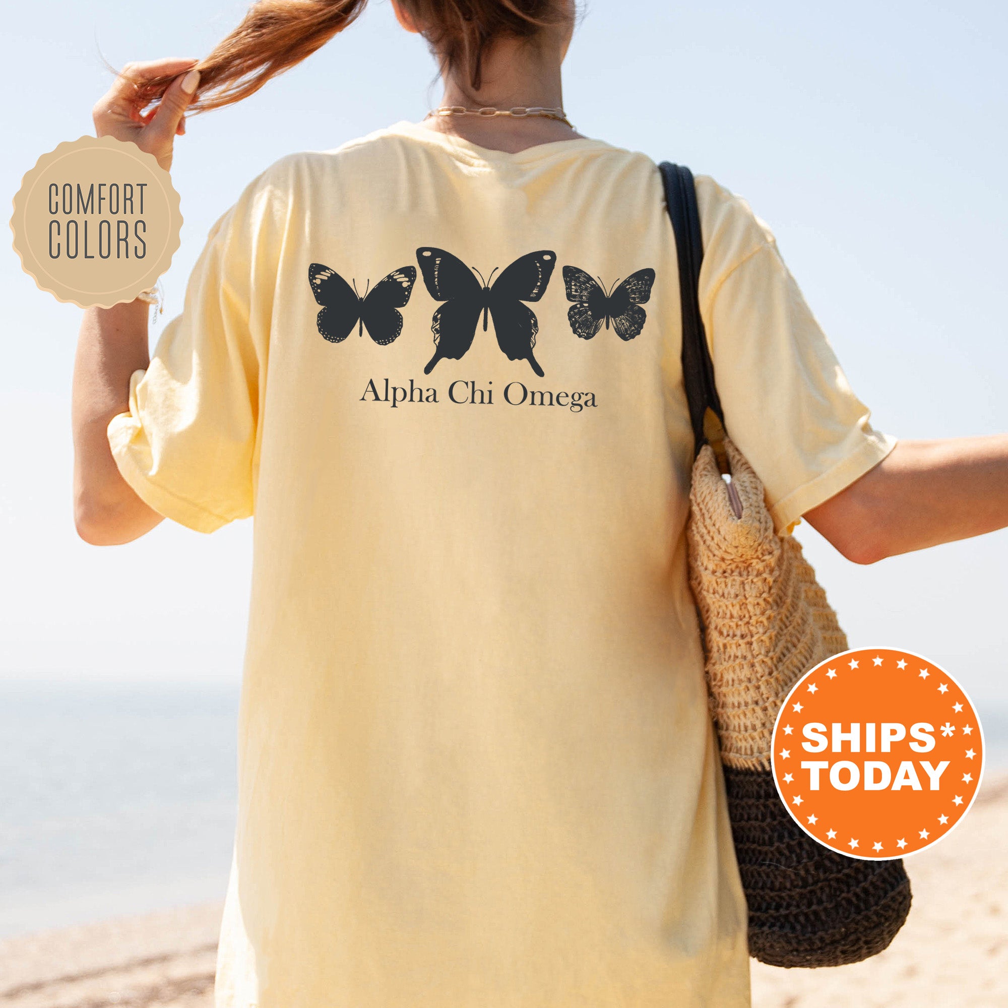 a woman walking on the beach with a butterfly shirt on