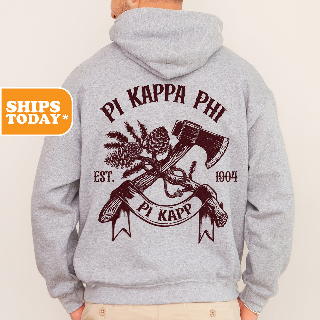 a man wearing a sweatshirt with a hammer and pine cone on it
