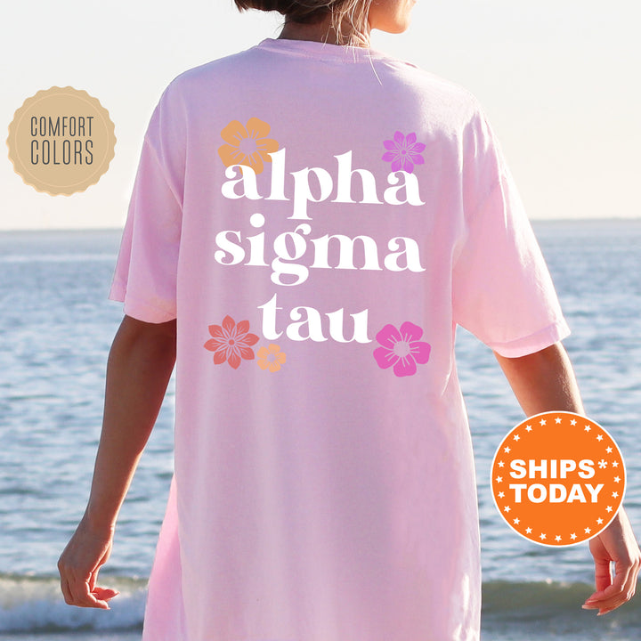 a woman standing on a beach wearing a pink shirt