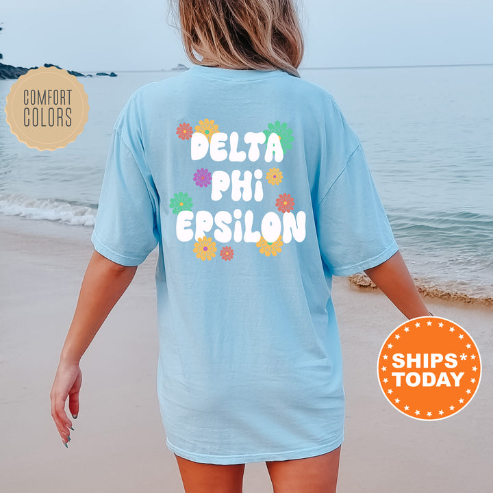 a woman walking on the beach wearing a t - shirt that says delta phi ep