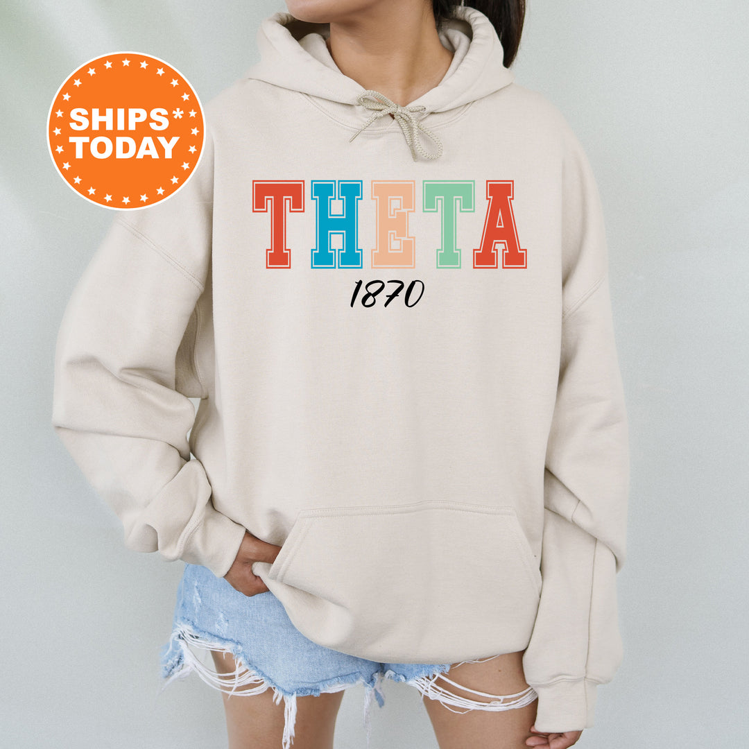 a woman wearing a sweatshirt with the word theta printed on it