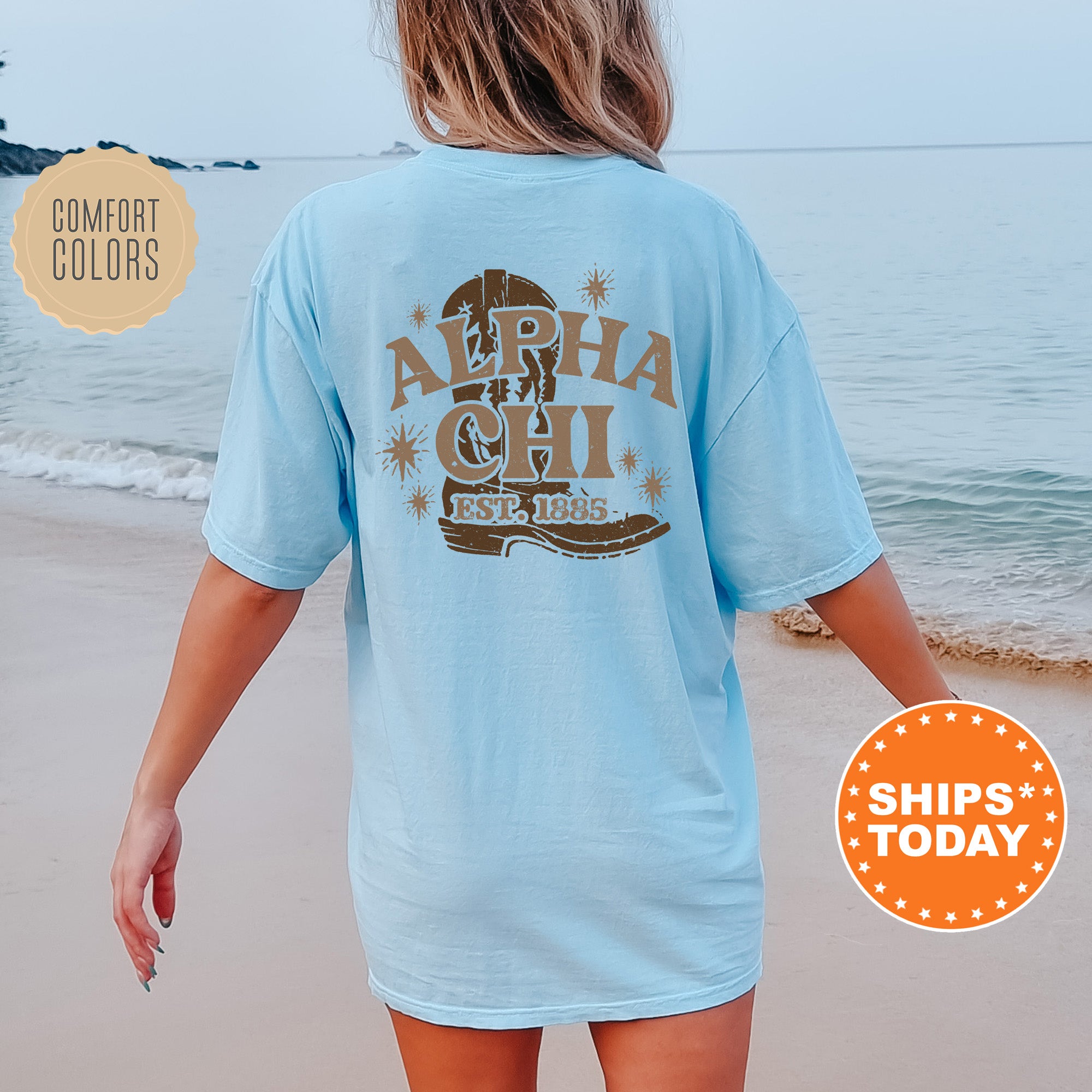 a woman walking on the beach wearing a light blue shirt