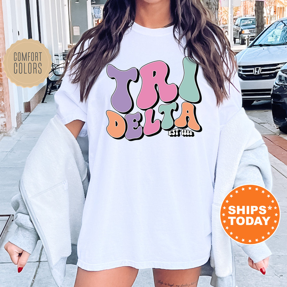 a woman wearing a white t - shirt with colorful letters on it