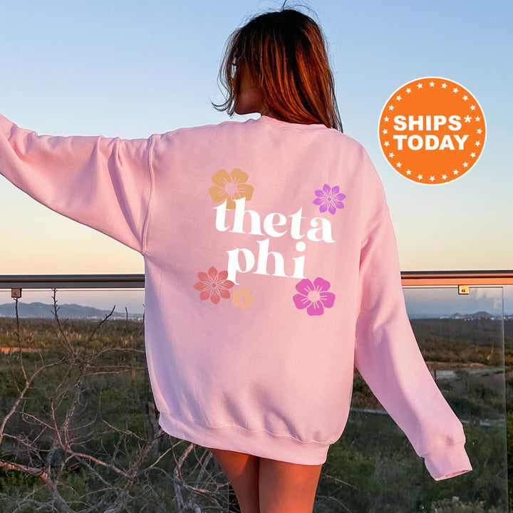 a woman wearing a pink sweatshirt with the words thea phi printed on it