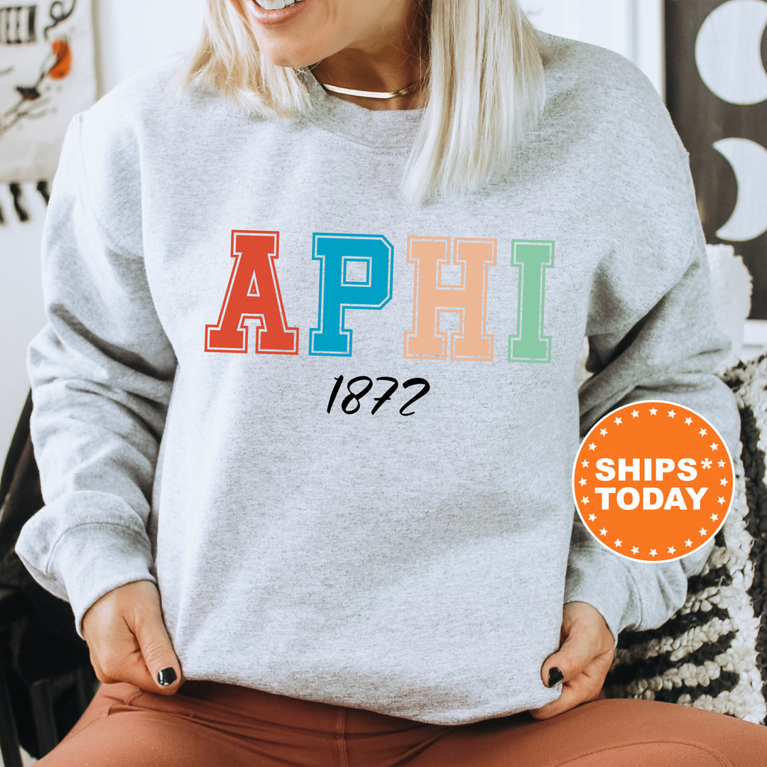 a woman sitting in a chair wearing a sweatshirt with the word aphi on it