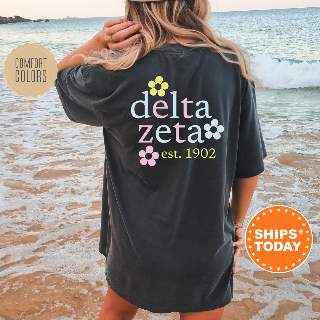 a woman standing on a beach wearing a black delta zeta shirt