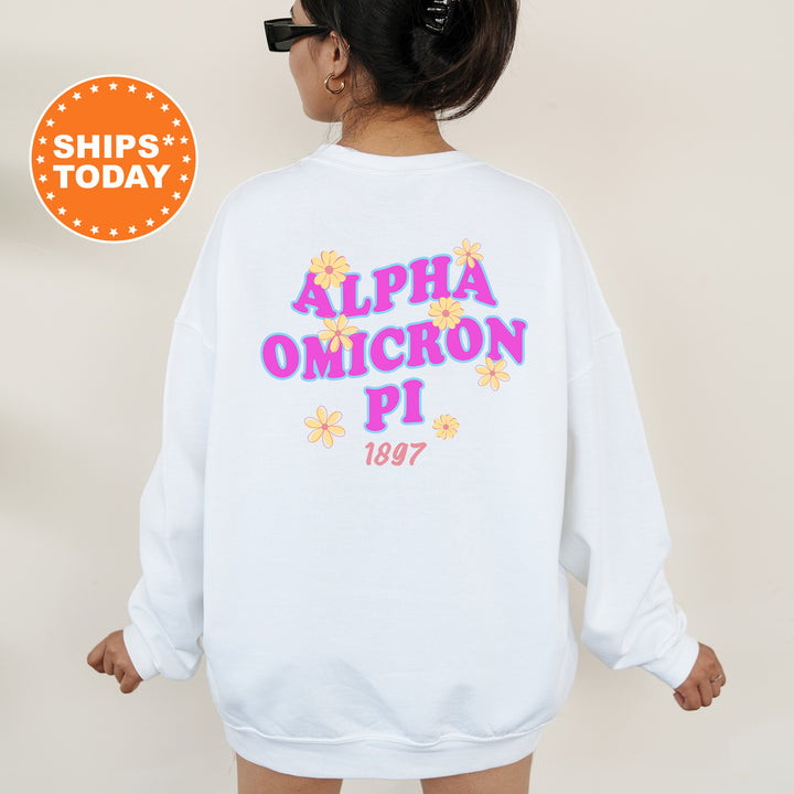 A person wearing a white sweatshirt with text and flowers printed on it.