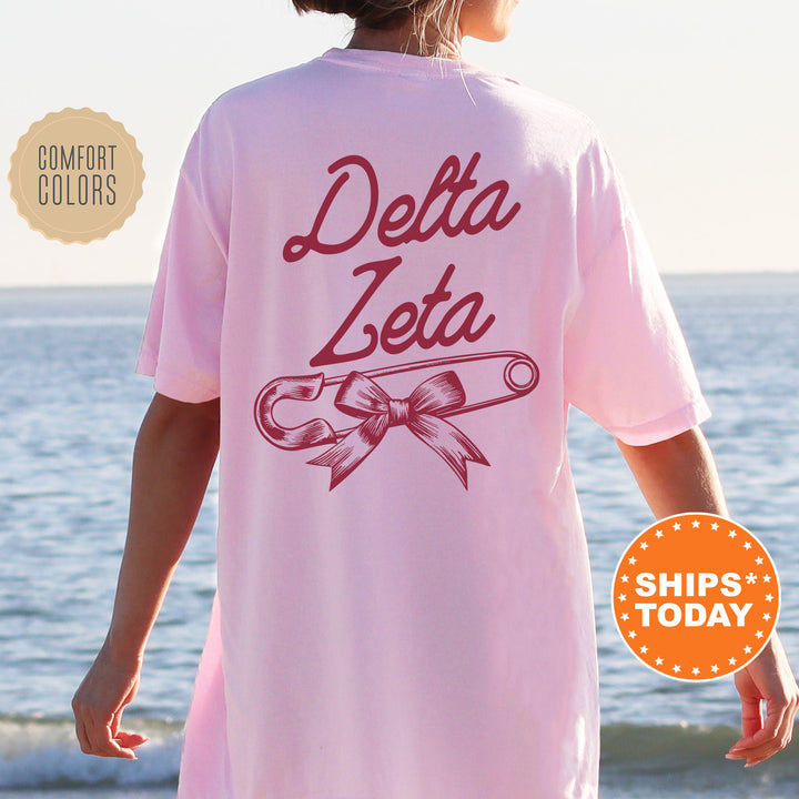 a woman wearing a pink delta delta shirt on the beach