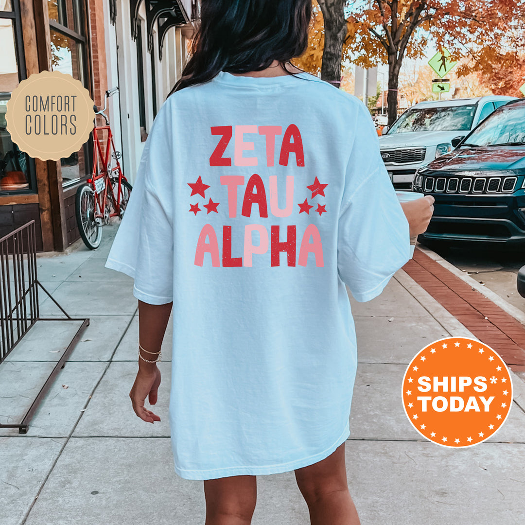 a woman is walking down the sidewalk wearing a t - shirt that says zeta