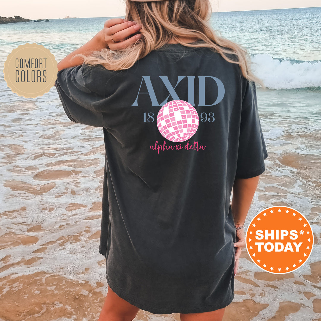 a woman standing on a beach wearing a black shirt