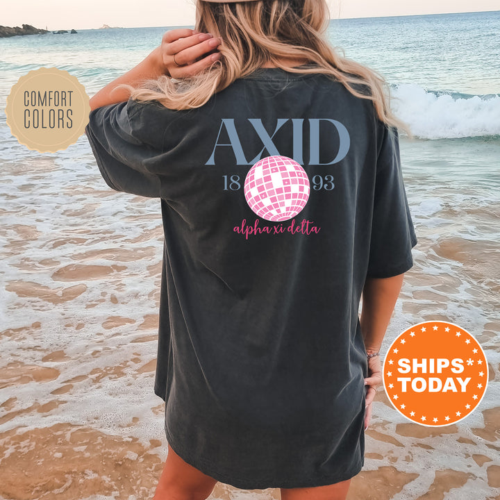 a woman standing on a beach wearing a black shirt