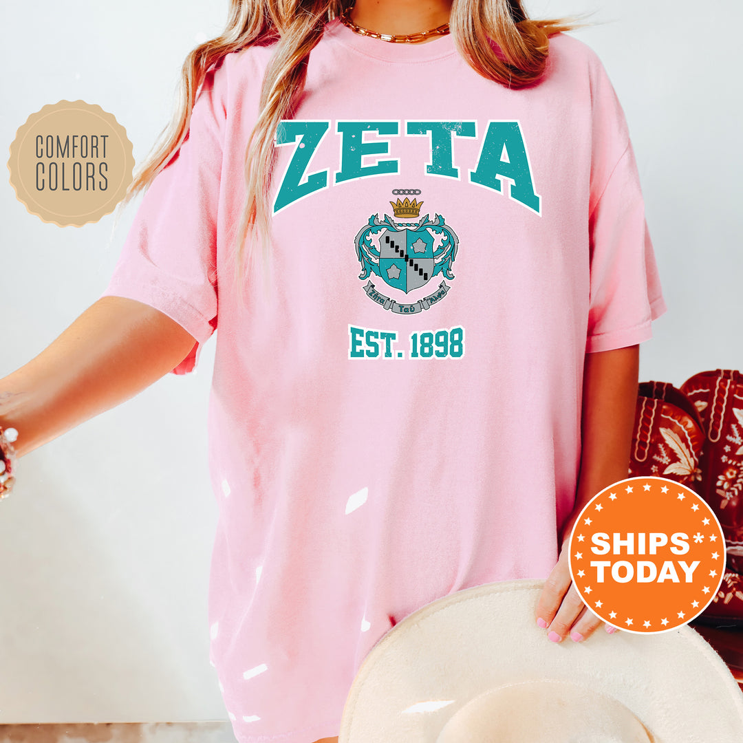 a woman wearing a pink zeta tshirt and hat
